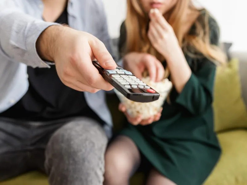 Image of a man changing the channel with a remote